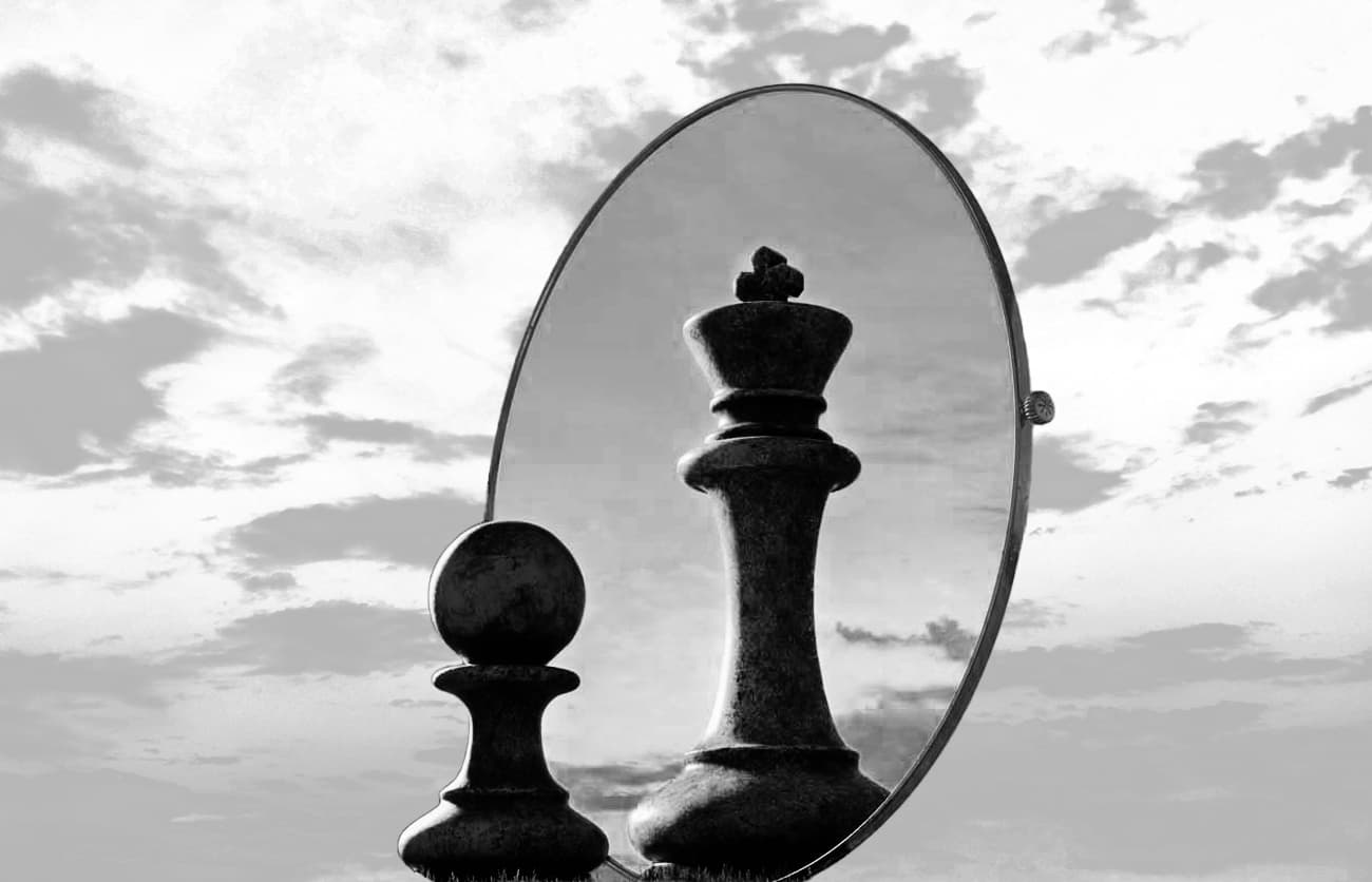 Small chess piece reflected as a powerful king